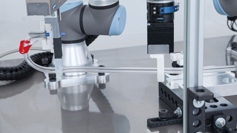 Zwei Industrieroboter, deren Bewegungen semi-synchronisiert aufeinander...